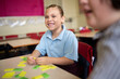 © Claire Bonnor/Austockphoto - Indigenous primary school student smiling working with coloured word tiles