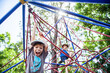 © Clare Farrelly/Austockphoto - Young boy climbing spiderweb playground equipment at park