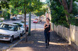 © Gillian Vann/Austockphoto - woman walking on footpath in inner city suburb