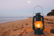 © Sophie Timothy/Austockphoto - Close up of kerosene lamp on beach at dusk