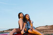 © JImena Roquero/Stocksy - Two young girls looking at sunset on top of a red car