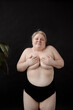 © Alina Hvostikova/Stocksy - Pretty huge woman hiding breast and smiling.