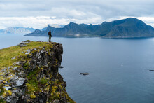 Traveler Observing Majestic Ocean Landscape From Rock