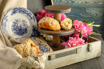 Wall Mural - Breakfast with croissants, leaves, flowers composition with retro plates on wooden background