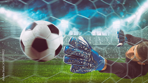 Fotografía Goalkeeper catches the ball in the stadium during a football game