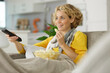 © auremar - woman at home eating snacks while watching television
