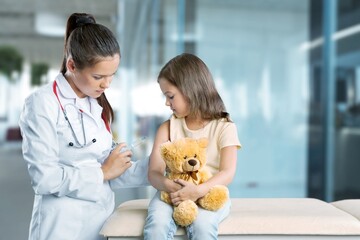 Wall Mural - Doctor vaccinating little girl on hospital background