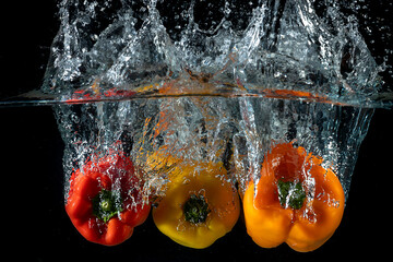 Wall Mural - three pepper on black background