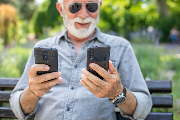 old man compare two smartphones