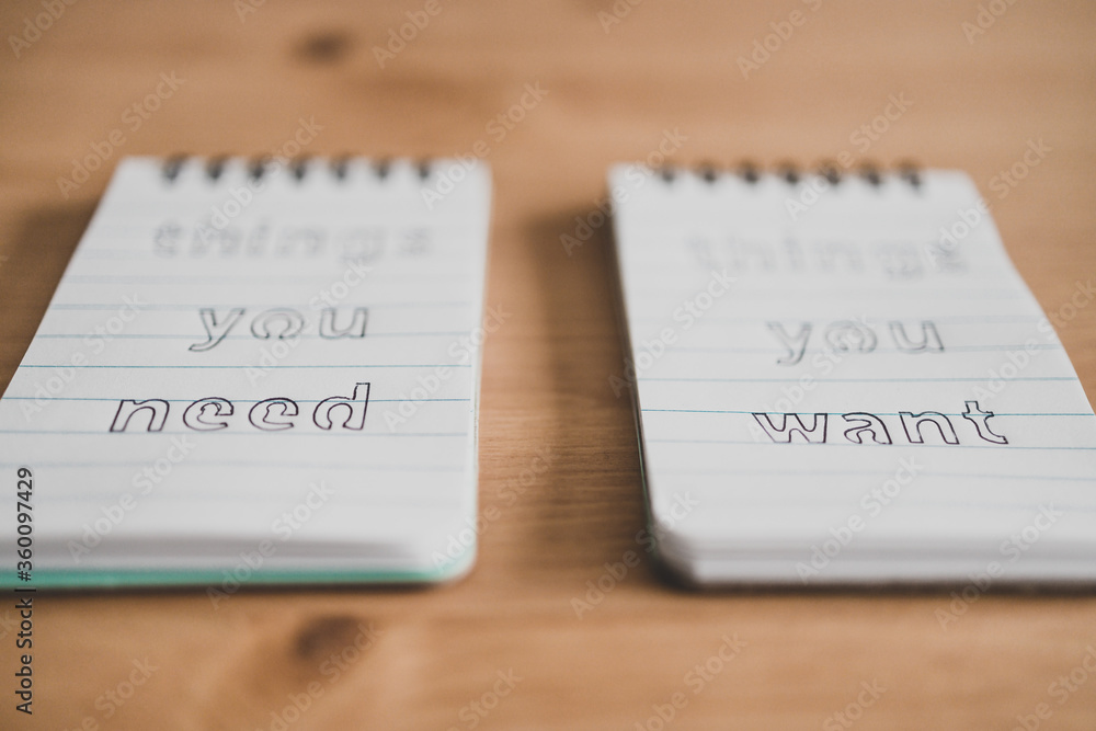 notepads with titles Things you need vs things you want side by side on ...