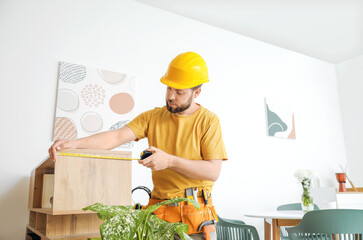 Wall Mural - Male carpenter using tape measure in room