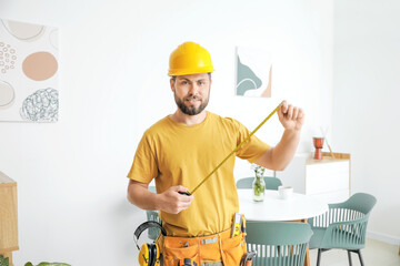 Wall Mural - Male carpenter with tape measure in room