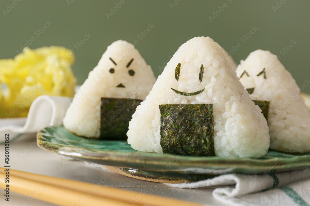 Plate with traditional Japanese onigiri on table, closeup