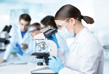 Wall Mural - the young scientist team has researching in the laboratory with a microscope.