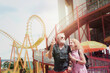 © Stella - Elderly couple spending time together at theme park on summer weekend, senior people hanging out and having fun at an amusement park.