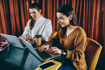 Wall Mural - successful female copywriters creating articles for website using good internet connection on laptop