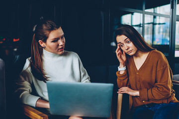Wall Mural - concentrated female it developers thinking on installing application on laptop computer, puzzled you