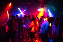 Blurred Silhouettes Of A Group Of People Dancing In A Nightclub On The Dance Floor Under Colorful Spotlights