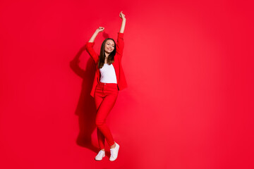 Wall Mural - Full body photo of attractive funny business lady success worker having fun corporate party colleagues event meeting wear blazer suit pants shoes isolated red color background