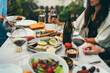 Friends dining together at home terrace enjoying meal and drinks, Mediterranean kitchen,Group of people eating healthy homemade food, Summer Dinner Party Concept