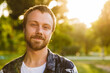 © Drobot Dean - Image of young caucasian man smiling while walking in summer park
