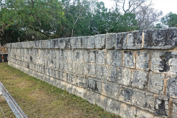 Ancient ruins in Chichen Itza, Mexico. The stone platform of the skulls is decorated with carvings in the form of many human skulls. All drawings are different and are located around the perimeter 