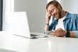 © Drobot Dean - Photo of man playing online game on cellphone while working with laptop