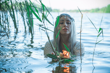 Old European magic, Mystical Pagan scene, woman in lake, rituals. Magic divination by candle of wax on the water, ritual. Psychic vision, fortune teller