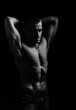 © Andrei Sasin - Athletic man's torso. Unrecognizable male fitness model show naked muscular body. Strong muscles and biceps. Studio shot on black background, monochrome, black and white. Bodybuilding concept