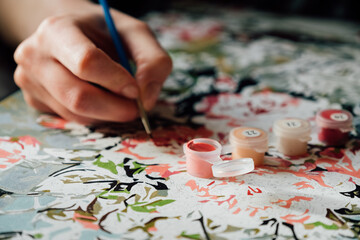 Young girl enjoying painting by numbers picture. Creative hobby. 