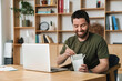 © Drobot Dean - Image of man eating asian noodles takeaway while working with laptop