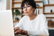 © Drobot Dean - Photo of serious woman working with laptop while sitting at table