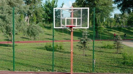 Wall Mural - Aerial view. Basketball court outside in a city park on a summer morning. Playground for sports among green trees and grass