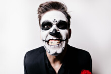 Crazy Young Man With Scary Makeup Posing In Studio. Indoor Shot Of Emotional Boy In Zombie Attire.