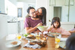 © trevor adeline/Caia Image - Affectionate wife kissing husband at dinner table