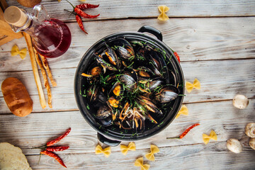 Wall Mural - Mussels in creamy sauce with parsley in a big black bucket