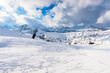 © alpegor - People kite skiing in a magnificent snowy mountain scenery in the European Alps on a sunny winter day