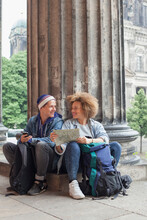 Smiling Young Tourist Sitting With Map At Altes Museum, Berlin, Germany