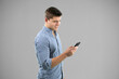 © WavebreakMediaMicro - Caucasian man using a smartphone on grey background