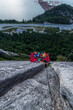 © Cavan Images - Top view of two men looking up and sitting on portaledge at sunset