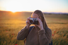 Girl Taking A Picture In The Field With Old Camera