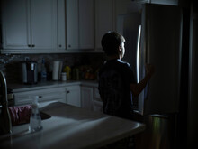 A 12 Year-old Boy Looks For A Late Night Snack In Refriderator