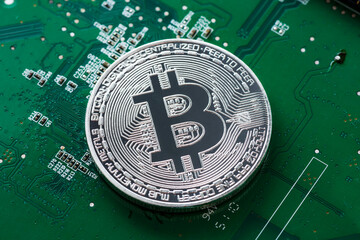 Canvas Print - Silver Bitcoin on green chipset. Close-up, macro shot.