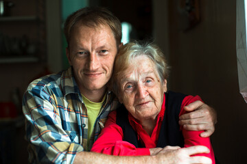 Wall Mural - Portrait of a man embracing his old grandmother.