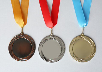 Gold, silver and bronze medals on white background, flat lay. Space for design