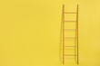 © New Africa - Modern wooden ladder on yellow background. Space for text