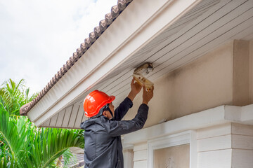 Electrician man working on exterior  light, install LED replacement lamp at home. Maintenance concept.