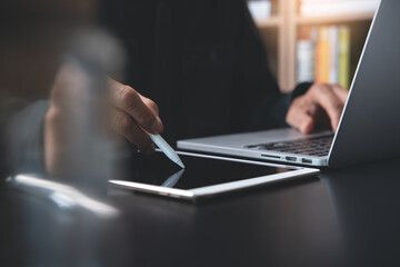 Canvas Print - Man working on digital tablet and laptop computer at home office or student learning online