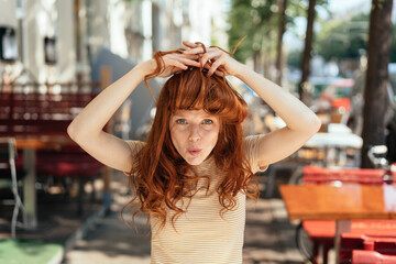 Wall Mural - Young woman making bangs with her long red hair