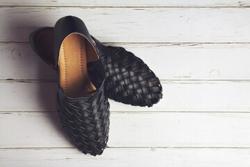 Girl's stylish leather shoes on wooden table
